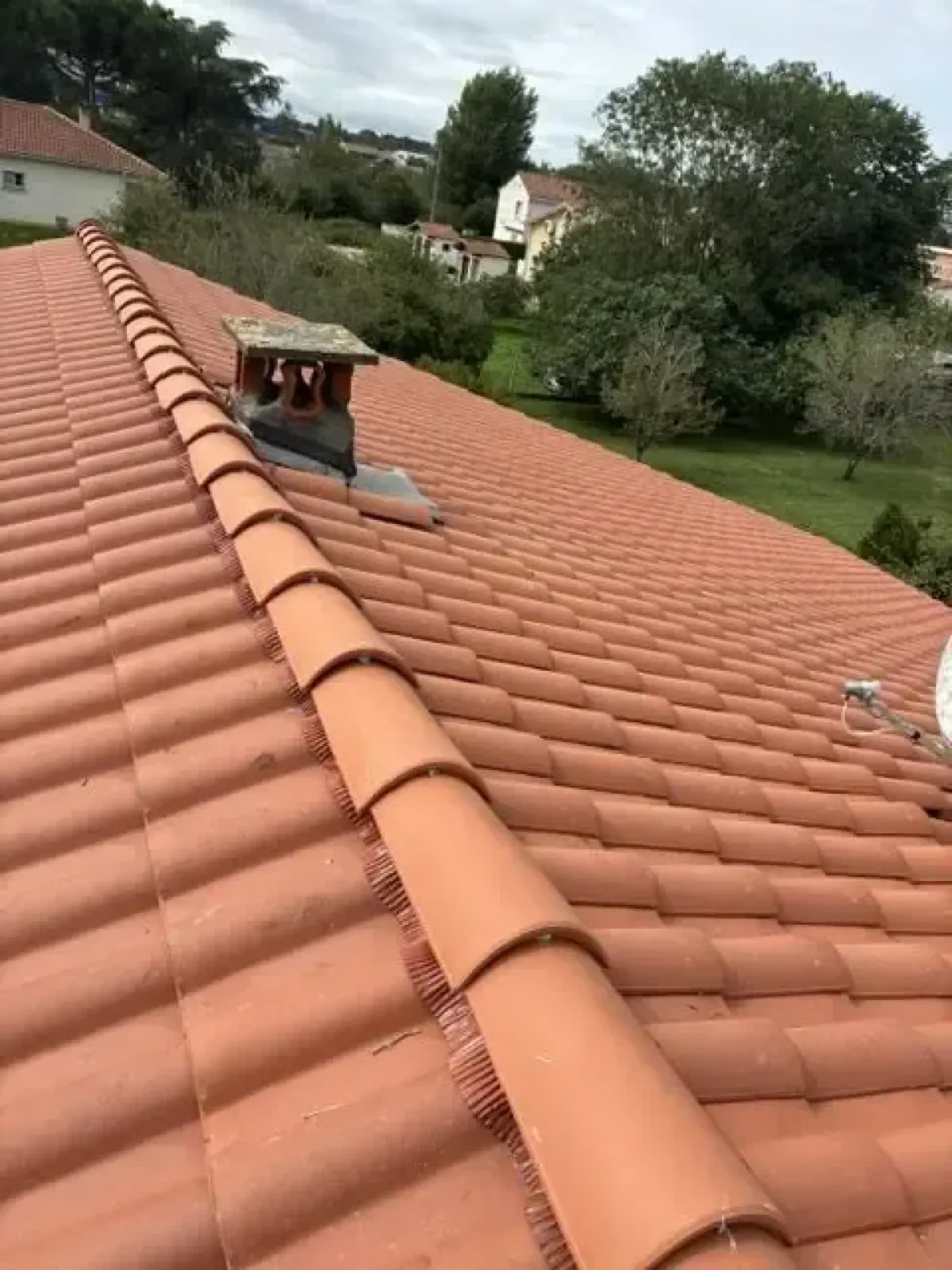 Couverture en tuiles canal neuves autour d’une souche de cheminée