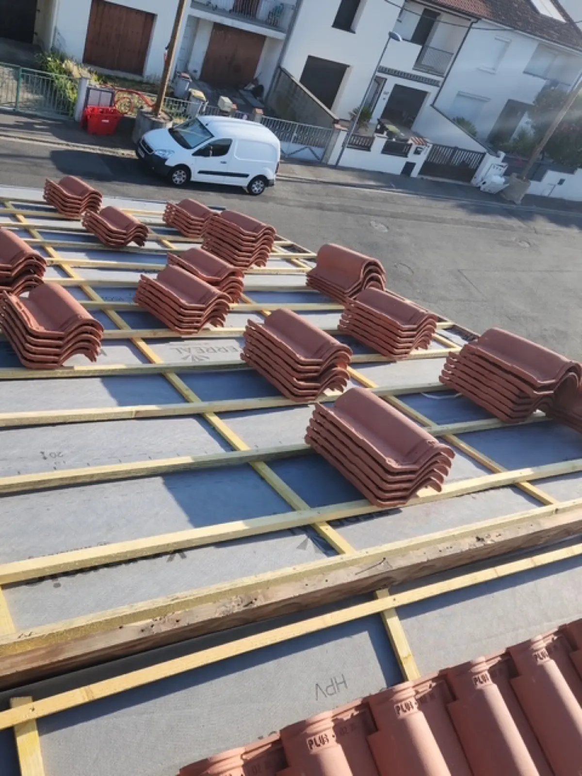 Pose de tuiles sur liteaux et écran sous-toiture, rue en contrebas